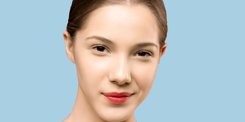 rhinocost20232 - JOSEPH Advanced Oculofacial Plastic Surgery Woman in front of blue wall with small smile and red lipstick